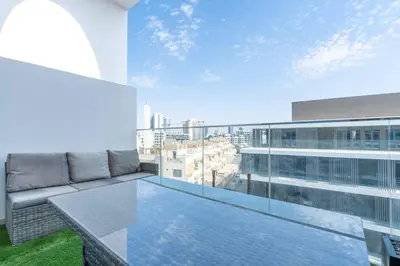 a balcony with a couch and a view of a city at Perfect 2br for families in JVC in Dubai