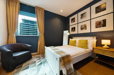a bedroom with a bed and a chair and a window at Maison Privee - Stunning 3-Floor Villa with Kids Room & Rooftop Terrace over Dubai Marina in Dubai