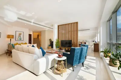 a living room with a white couch and blue chairs at Maison Privee - Stunning 3-Floor Villa with Kids Room & Rooftop Terrace over Dubai Marina in Dubai