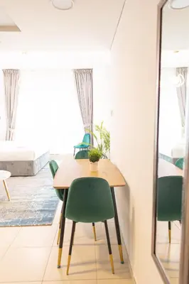a dining room with a table and green chairs at Royal Oceanic in JBR by HAPPY SEASON in Dubai