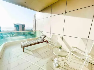 a balcony with a bench and chairs on a building at Royal Oceanic in JBR by HAPPY SEASON in Dubai