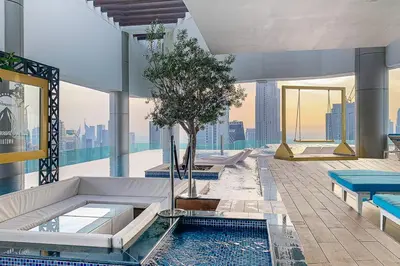 a building with a pool with a tree in it at Frank Porter - Paramount Midtown in Dubai