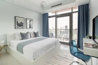 a white bedroom with a bed and a large window at Frank Porter - Paramount Midtown in Dubai
