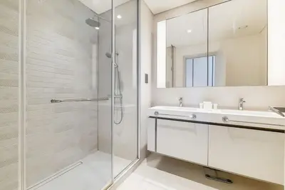 a bathroom with a shower and a sink and a mirror at Sunrise Bay 2 - Chic Two Bedroom in Dubai