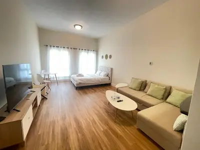 a living room with a couch and a table at Stylish Studio in Discovery Garden MED100 in Dubai