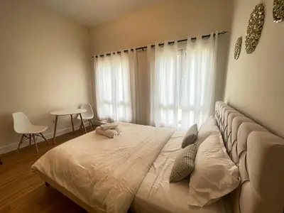 a bedroom with a large white bed in front of a window at Stylish Studio in Discovery Garden MED100 in Dubai