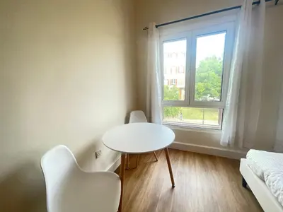 a white table and chairs in a room with a window at Stylish Studio in Discovery Garden MED100 in Dubai