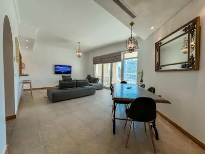 a living room with a table and a couch at Upgraded 2BR apartment at the beach - Shoreline 1 in Dubai
