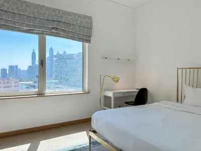 a bedroom with a bed and a large window at Upgraded 2BR apartment at the beach - Shoreline 1 in Dubai