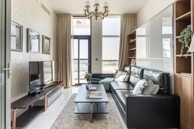 a living room with a black leather couch and a tv at Frank Porter - Starz by Danube in Dubai