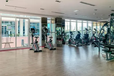 a gym with treadmills and exercise bikes in a building at Frank Porter - Starz by Danube in Dubai