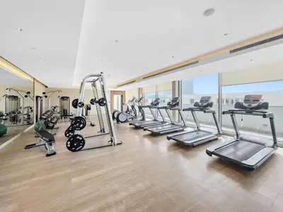 a gym with a row of treadmills and machines at New 2 bedroom in Meydan - Green Area in Dubai