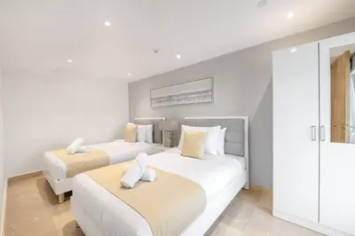 two beds in a bedroom with white walls at Ultra Luxury JBR Duplex Penthouse - Free 5 star beach access in Dubai