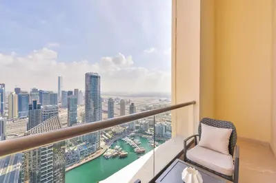 a balcony with a chair and a view of a city at Ultra Luxury JBR Duplex Penthouse - Free 5 star beach access in Dubai