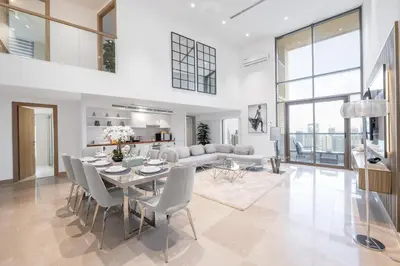 a dining room and living room with a table and chairs at Ultra Luxury JBR Duplex Penthouse - Free 5 star beach access in Dubai