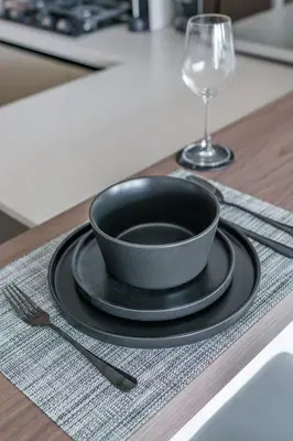 a black bowl on a plate on a table with a glass at GuestReady - Luxe Suite in Jumeirah Marina in Dubai