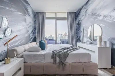 a bedroom with a bed and a large window at GuestReady - Luxe Suite in Jumeirah Marina in Dubai