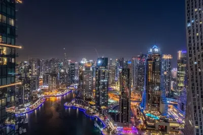 a city skyline at night with a river and buildings at GuestReady - Luxe Suite in Jumeirah Marina in Dubai