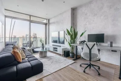 a living room with a couch and a desk with a television at GuestReady - Luxe Suite in Jumeirah Marina in Dubai
