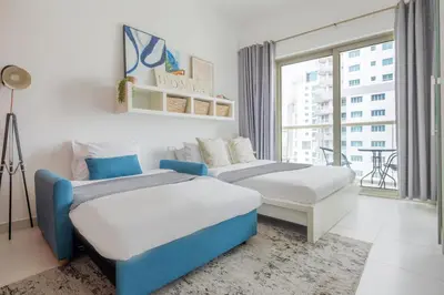 two beds in a room with a window at Frank Porter - Marina Views T1 in Dubai