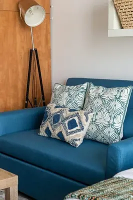 a blue couch with a pillow and a lamp at Frank Porter - Marina Views T1 in Dubai