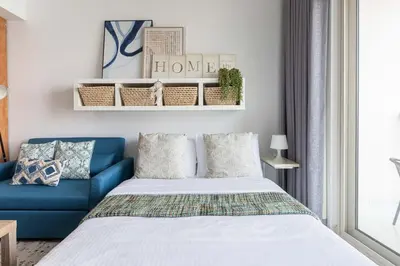 a bedroom with a bed and a blue couch at Frank Porter - Marina Views T1 in Dubai