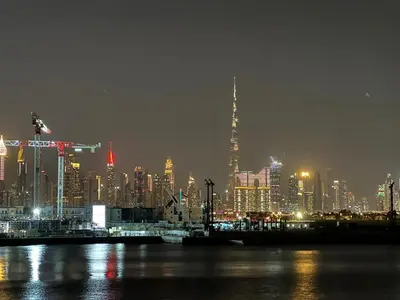 a view of a city skyline at night at 2BR Le Pont B3 Full Sea and Pool View in Dubai