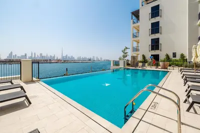 a swimming pool in a building with a view of the water at 2BR Le Pont B3 Full Sea and Pool View in Dubai