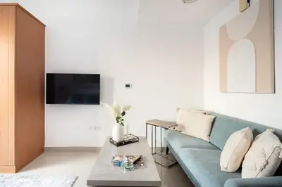a living room with a blue couch and a table at Frank Porter - Lakeside Tower D in Dubai