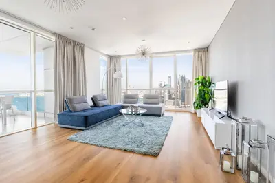 a living room with a blue couch and a tv at Ultra Luxe 5BR Al Bateen I Private Beach and Pool I JBR Full Sea View Beachfront in Dubai