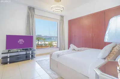 a bedroom with a large bed and a large window at JBR - Apartment plus maid in Dubai
