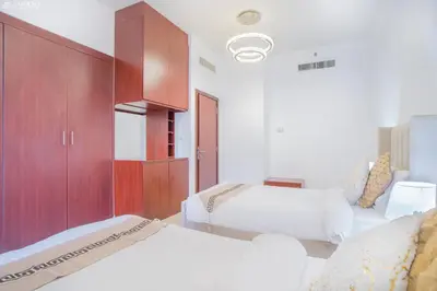 a bedroom with two beds and a cabinet at JBR - Apartment plus maid in Dubai