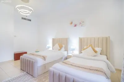 two beds in a room with white walls at JBR - Apartment plus maid in Dubai
