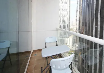 a balcony with two chairs and a table in a building at RH- Voguish, Studio in Downtown, short walk to Burj Khalifa in Dubai