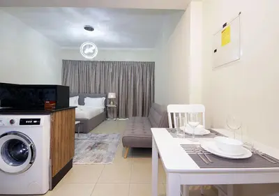 a living room with a kitchen and a living room with a washing machine at RH- Voguish, Studio in Downtown, short walk to Burj Khalifa in Dubai