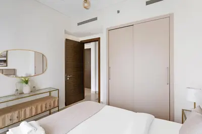 a bedroom with a white bed and a mirror at Beautiful 2 bedroom next to Business Bay - Sobha Creek Vista in Dubai