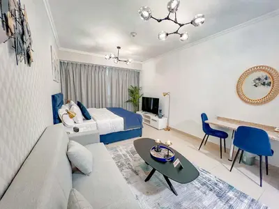 a hotel room with a bed and a living room at Cosmos Living Elegant Studio Near Dubai Marina in Dubai