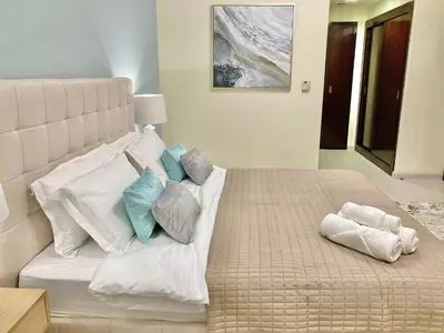 a bedroom with a large bed with pillows on it at White Sage - Lakefront Apartment Amidst Parks With Lake Access in Dubai