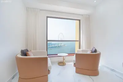 a room with two chairs and a table and a large window at JBR - Shams Suites - Sea & Marina View Walking Distance to The Beach by Gardenia in Dubai