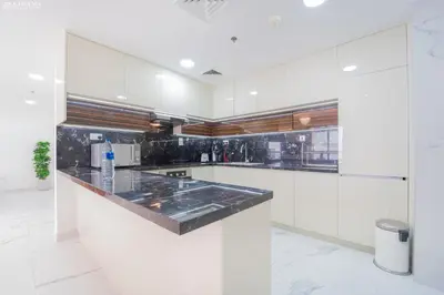 a kitchen with white cabinets and a black counter top at JBR - Shams Suites - Sea & Marina View Walking Distance to The Beach by Gardenia in Dubai