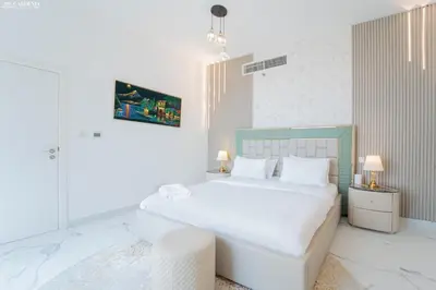 a white bedroom with a large white bed in it at JBR - Shams Suites - Sea & Marina View Walking Distance to The Beach by Gardenia in Dubai