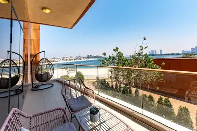 a balcony with two chairs and a view of the water at Tiara Residences, Palm Jumeirah Dubai - Mint Stay in Dubai