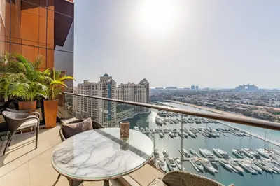 a balcony with a table and a view of a harbor at Tiara Residences, Palm Jumeirah Dubai - Mint Stay in Dubai