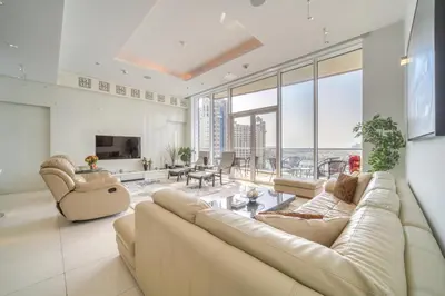 a living room with a couch and chairs and windows at Tiara Residences, Palm Jumeirah Dubai - Mint Stay in Dubai
