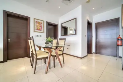 a dining room with a wooden table and chairs at Tiara Residences, Palm Jumeirah Dubai - Mint Stay in Dubai