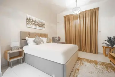 a bedroom with a large bed and a large window at Everluxe Azizi Montrell Lovely Studio in Dubai