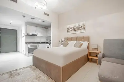 a bedroom with a large bed and a couch at Everluxe Azizi Montrell Lovely Studio in Dubai