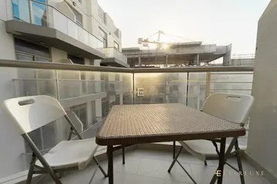 a balcony with a table and two chairs on a balcony at Everluxe Azizi Montrell Lovely Studio in Dubai