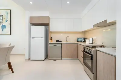 a kitchen with a white refrigerator and a sink at Lux BnB The Grand Creek Harbor Views in Dubai