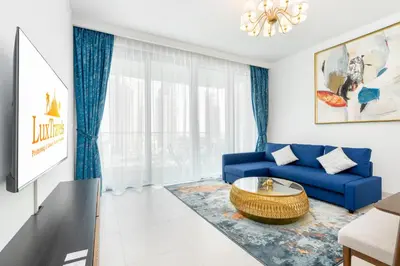 a living room with a blue couch and a table at Lux BnB The Grand Creek Harbor Views in Dubai